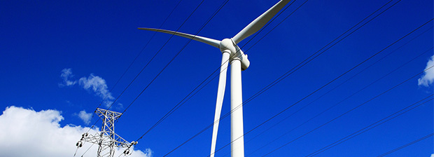 Wind turbine, powerlines and blue sky.