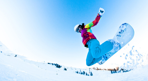 Snowboarder boarding down a hill.