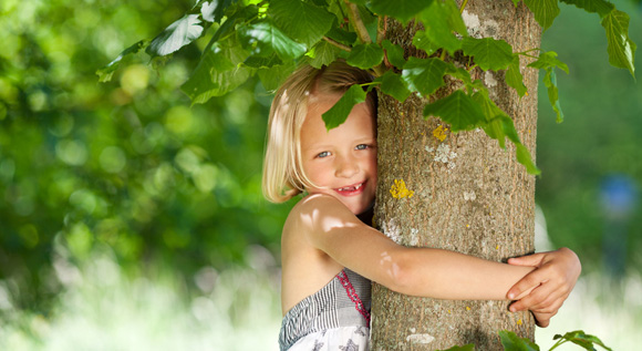 Girl embracing tree.