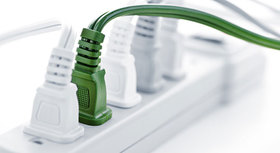 Multiple socket with several white plugs and a green one