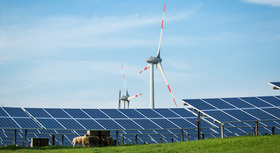 Photovoltaikanlagen und Windräder hinter einer Viehweide