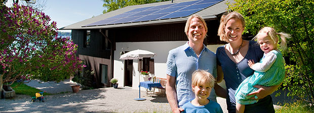 Eine Familie steht vor ihrem Haus mit Solardach, symbolisiert Deutschland machts effizient